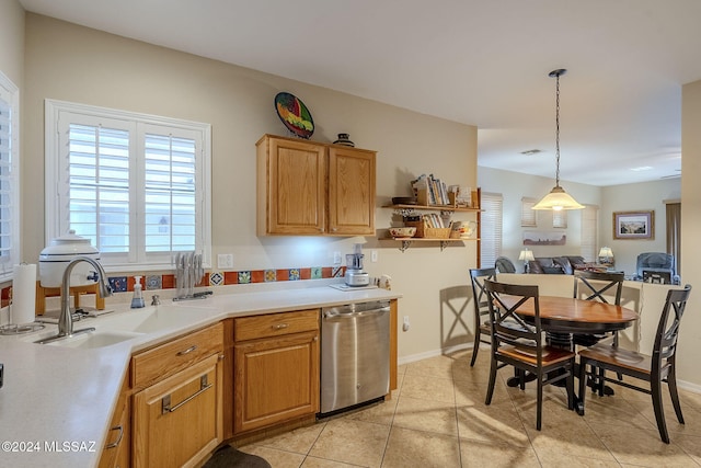 kitchen featuring dishwasher, pendant lighting, light tile patterned floors, and sink