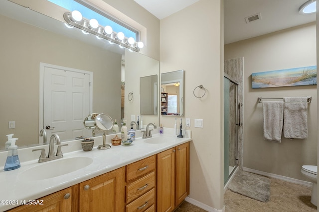 bathroom with toilet, vanity, tile patterned floors, and a shower with shower door