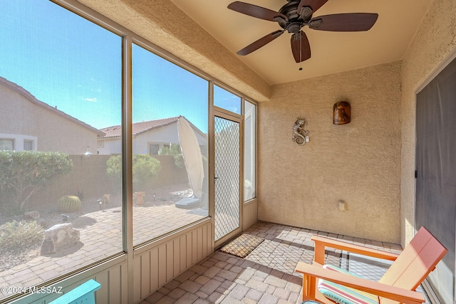 unfurnished sunroom with ceiling fan