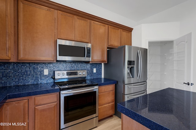 kitchen with decorative backsplash, light hardwood / wood-style floors, and appliances with stainless steel finishes