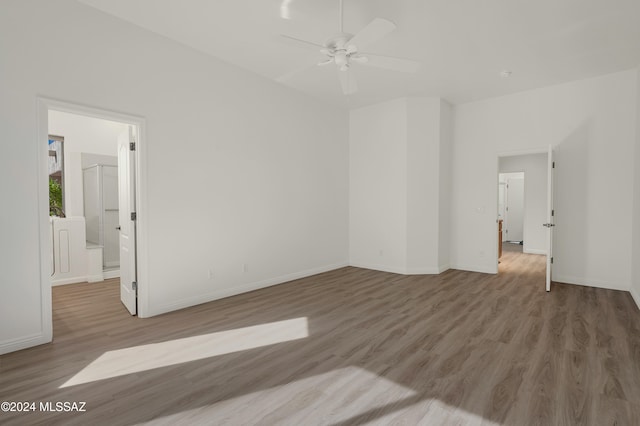 empty room with ceiling fan and light hardwood / wood-style floors