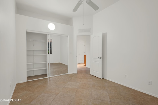 unfurnished bedroom with a closet, ceiling fan, and light tile patterned flooring