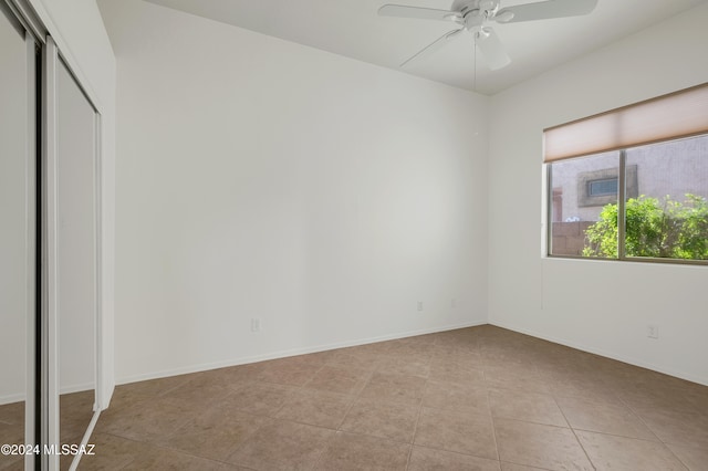 interior space featuring ceiling fan, light tile patterned floors, and a closet