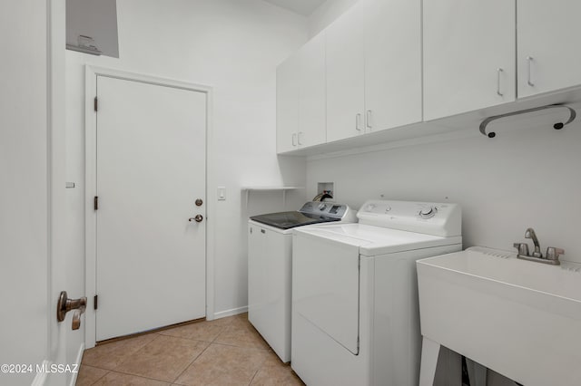 clothes washing area with cabinets, independent washer and dryer, light tile patterned flooring, and sink