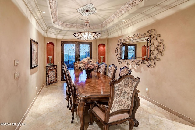 dining area featuring a tray ceiling, ornamental molding, and french doors