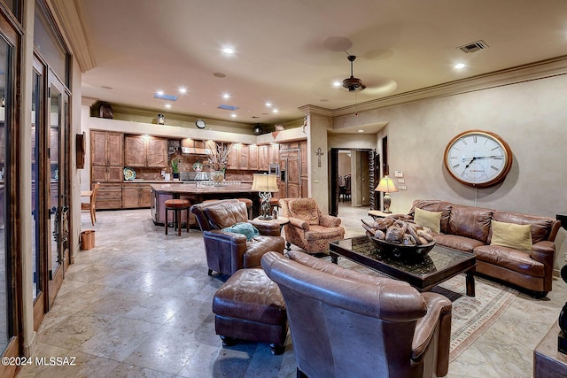 living room with ceiling fan and ornamental molding