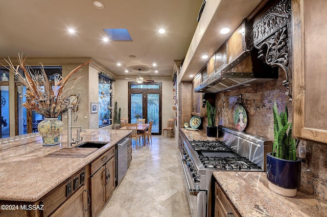 kitchen with crown molding, premium range hood, appliances with stainless steel finishes, light stone counters, and french doors