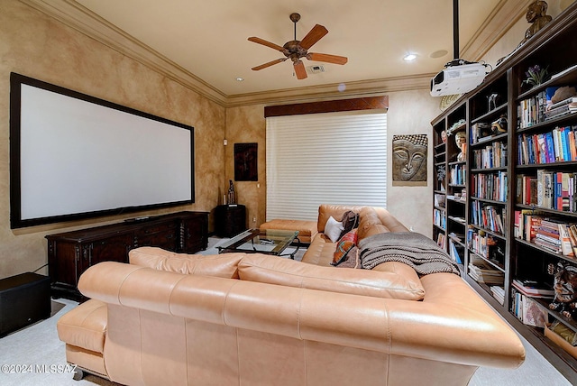 carpeted cinema room with ceiling fan and ornamental molding