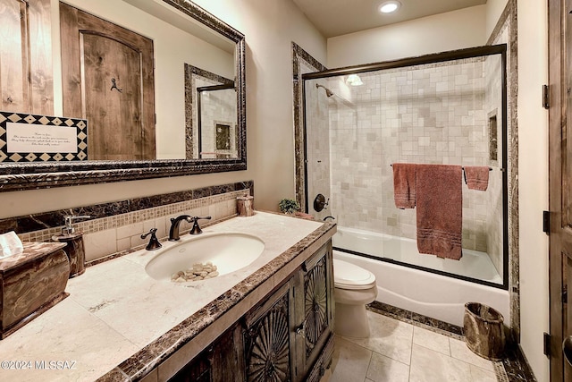 full bathroom with combined bath / shower with glass door, backsplash, vanity, toilet, and tile patterned floors