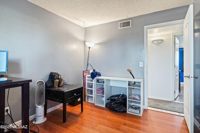 office space with light hardwood / wood-style floors and a textured ceiling