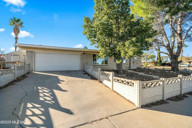 ranch-style home with a storage shed and a garage