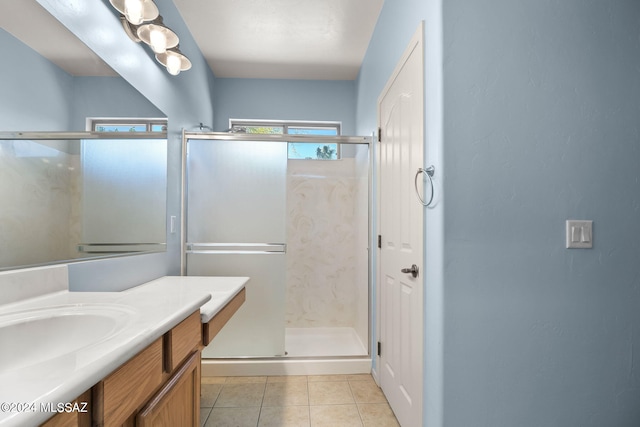 full bathroom featuring a stall shower, tile patterned flooring, and vanity