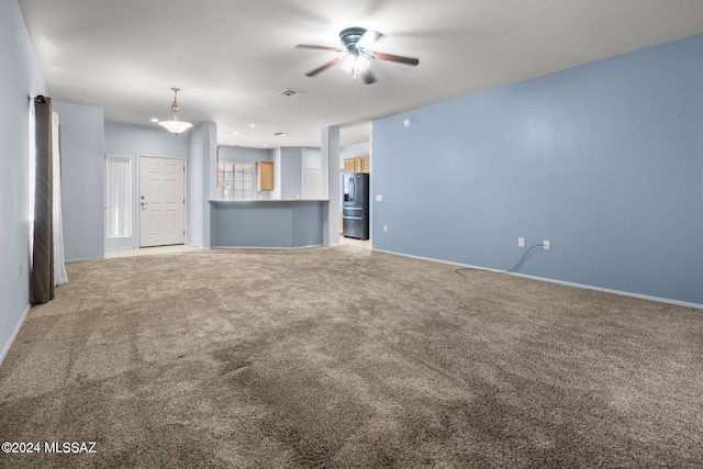 unfurnished living room featuring baseboards, a ceiling fan, visible vents, and light carpet