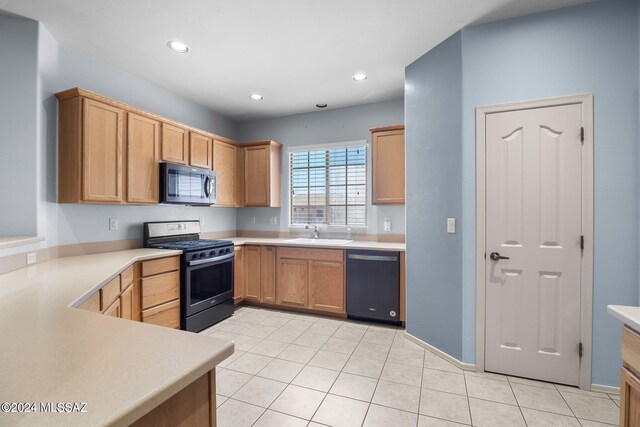 kitchen with light tile patterned floors, stainless steel appliances, a sink, and light countertops