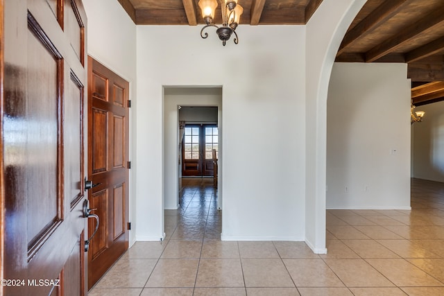 entrance foyer with beam ceiling, light tile patterned floors, and wood ceiling