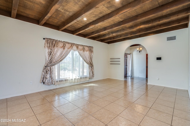 tiled empty room with beamed ceiling, a notable chandelier, and wooden ceiling