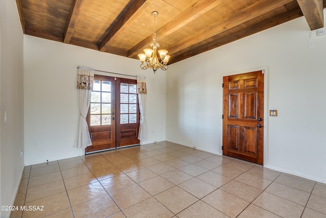 tiled empty room with a chandelier, french doors, beamed ceiling, and wood ceiling