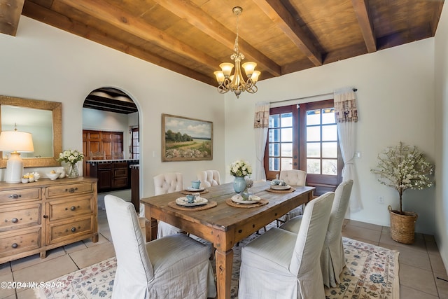 tiled dining space with beam ceiling, french doors, wooden ceiling, and an inviting chandelier