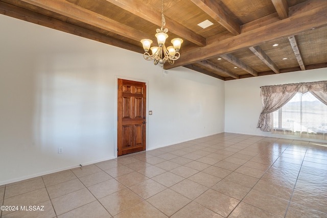 spare room with beamed ceiling, wood ceiling, light tile patterned floors, and an inviting chandelier