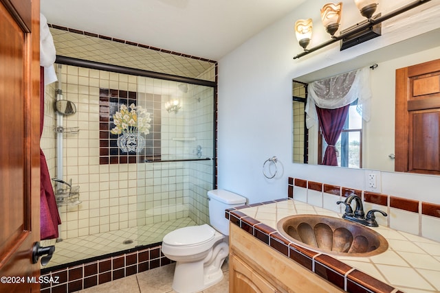 bathroom featuring tile patterned floors, vanity, toilet, and a shower with door