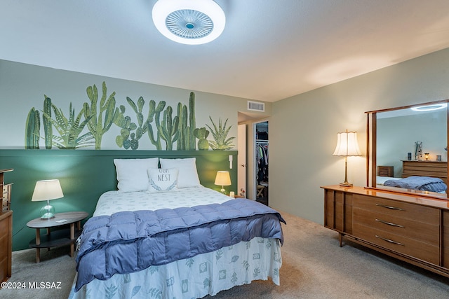 bedroom with carpet and a walk in closet