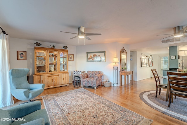 living room featuring ceiling fan and hardwood / wood-style floors