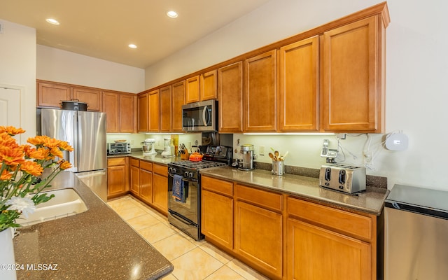 kitchen featuring light tile patterned floors, recessed lighting, stainless steel appliances, brown cabinets, and dark stone counters