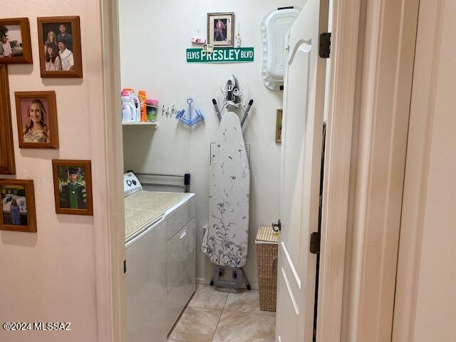 laundry area featuring laundry area, light tile patterned flooring, and washing machine and clothes dryer