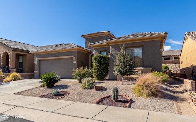 prairie-style house with a garage, driveway, a tiled roof, and stucco siding