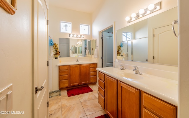 full bath featuring two vanities, a sink, a shower with door, and tile patterned floors