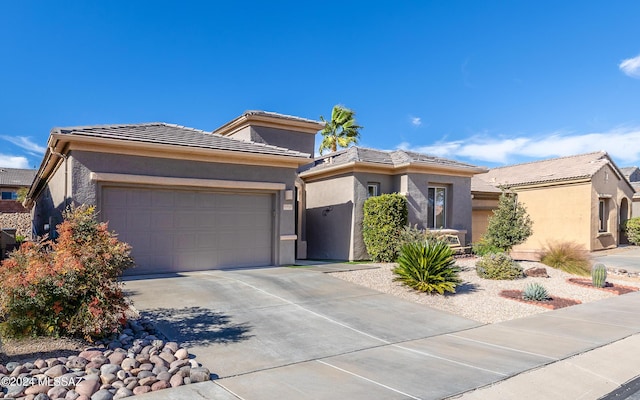 prairie-style house featuring a garage, a tiled roof, concrete driveway, and stucco siding