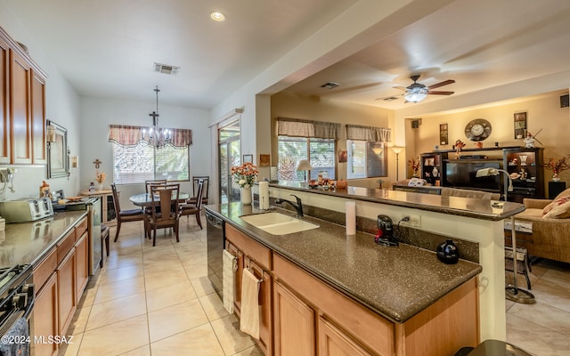 kitchen with a sink, visible vents, open floor plan, black appliances, and an island with sink