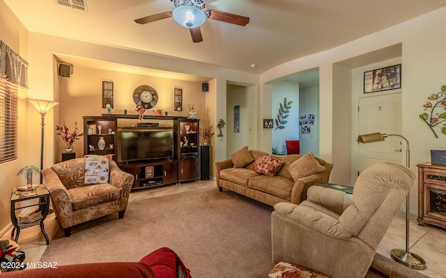 tiled living room with carpet floors and a ceiling fan