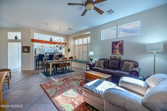 living room with ceiling fan with notable chandelier