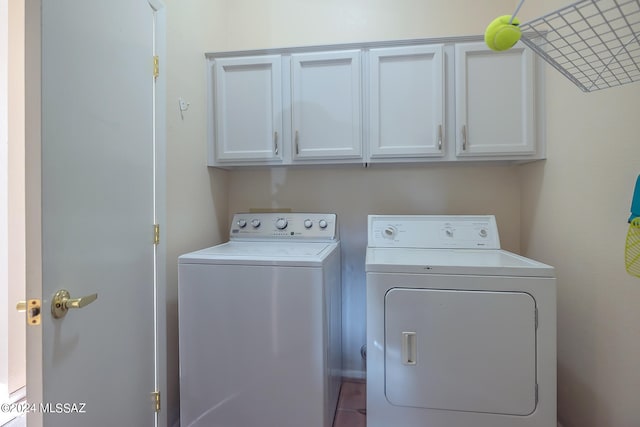 laundry room featuring cabinets, independent washer and dryer, and tile patterned flooring