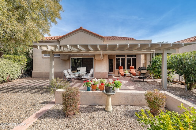 rear view of property featuring a pergola and a patio