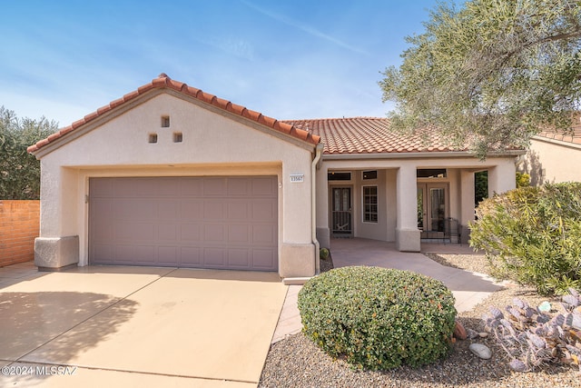 mediterranean / spanish home featuring a porch and a garage