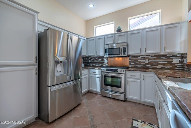 kitchen with decorative backsplash, appliances with stainless steel finishes, white cabinetry, and sink