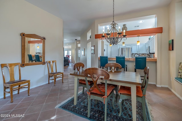 dining area with dark tile patterned flooring and a notable chandelier