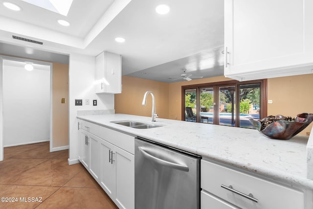 kitchen featuring white cabinets, light tile patterned floors, stainless steel dishwasher, and sink