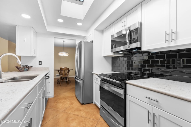 kitchen featuring light tile patterned floors, white cabinetry, sink, and appliances with stainless steel finishes