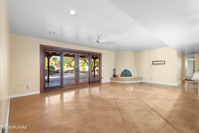 unfurnished living room featuring ceiling fan, light tile patterned flooring, and french doors