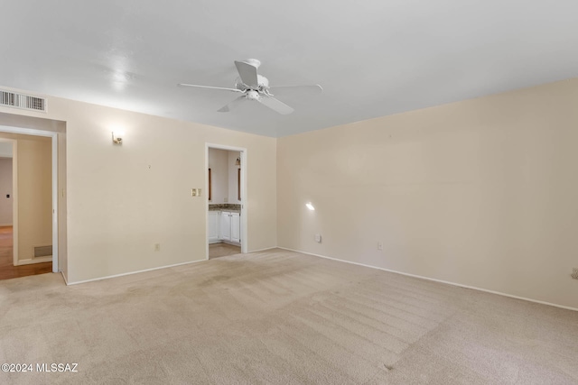 carpeted spare room featuring ceiling fan