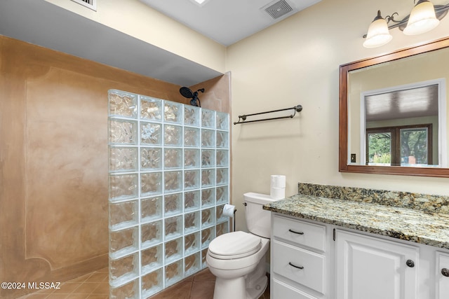 bathroom with a shower, tile patterned flooring, vanity, and toilet