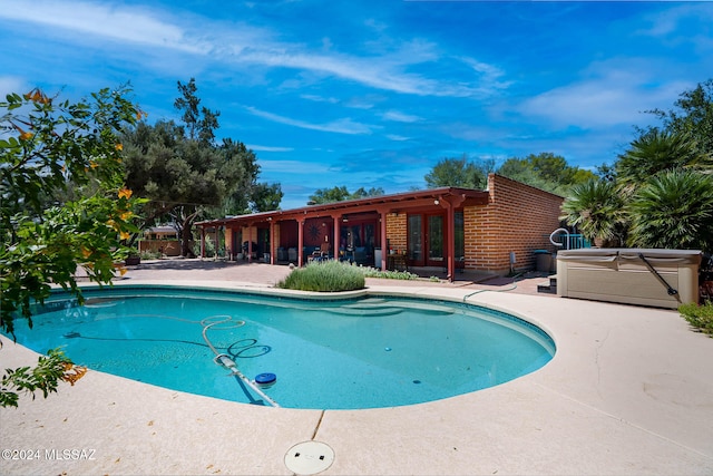 view of pool with a patio area, french doors, and a hot tub