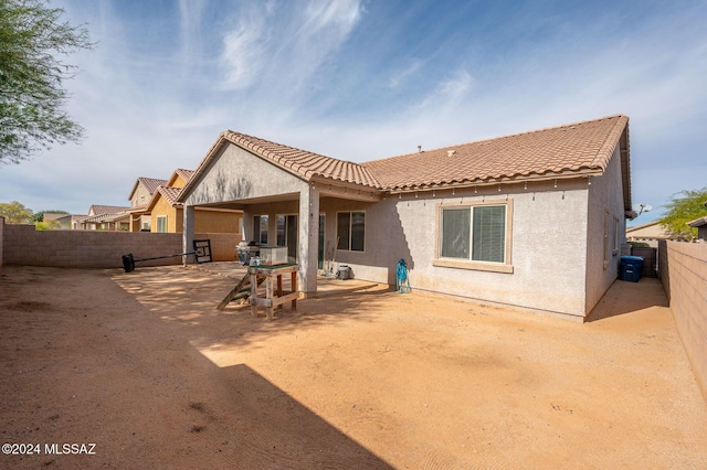 back of house featuring a patio area, a fenced backyard, stucco siding, and a tiled roof