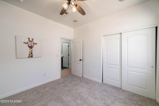 unfurnished bedroom with ceiling fan, a closet, and light colored carpet