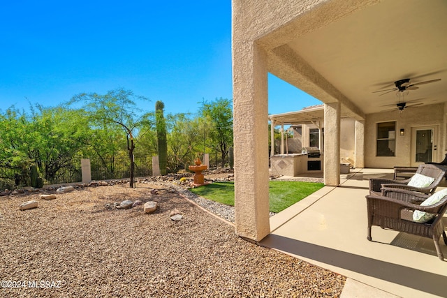 view of patio / terrace with ceiling fan and an outdoor kitchen