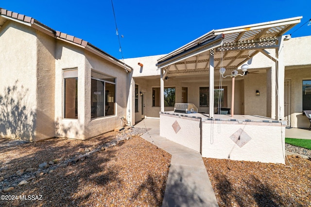 back of house featuring ceiling fan, a patio area, exterior kitchen, and a pergola