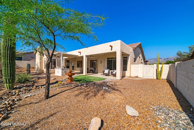 rear view of house featuring a patio area, ceiling fan, and an outdoor kitchen